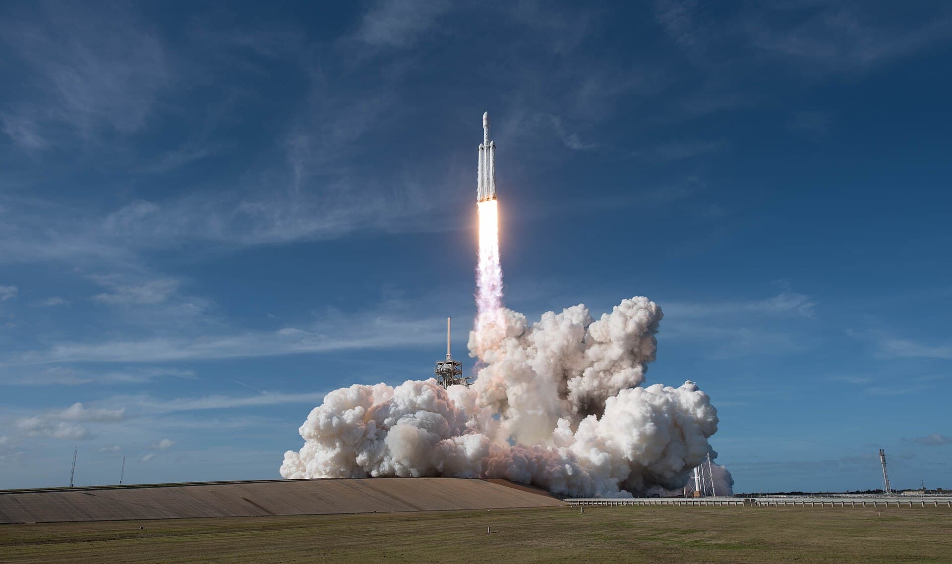 Un razzo Falcon Heavy di SpaceX si prepara al lancio, con il cielo all'alba sullo sfondo.