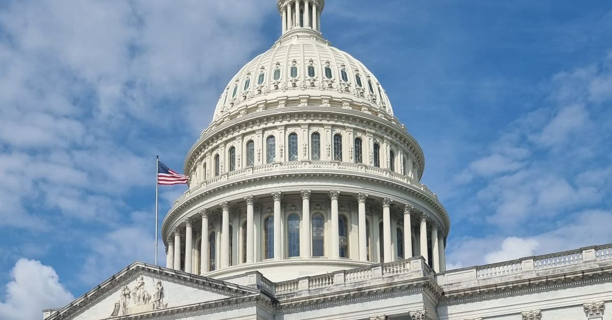 Il Campidoglio degli Stati Uniti, simbolo del potere politico ed economico americano, su uno sfondo urbano con grattacieli moderni.