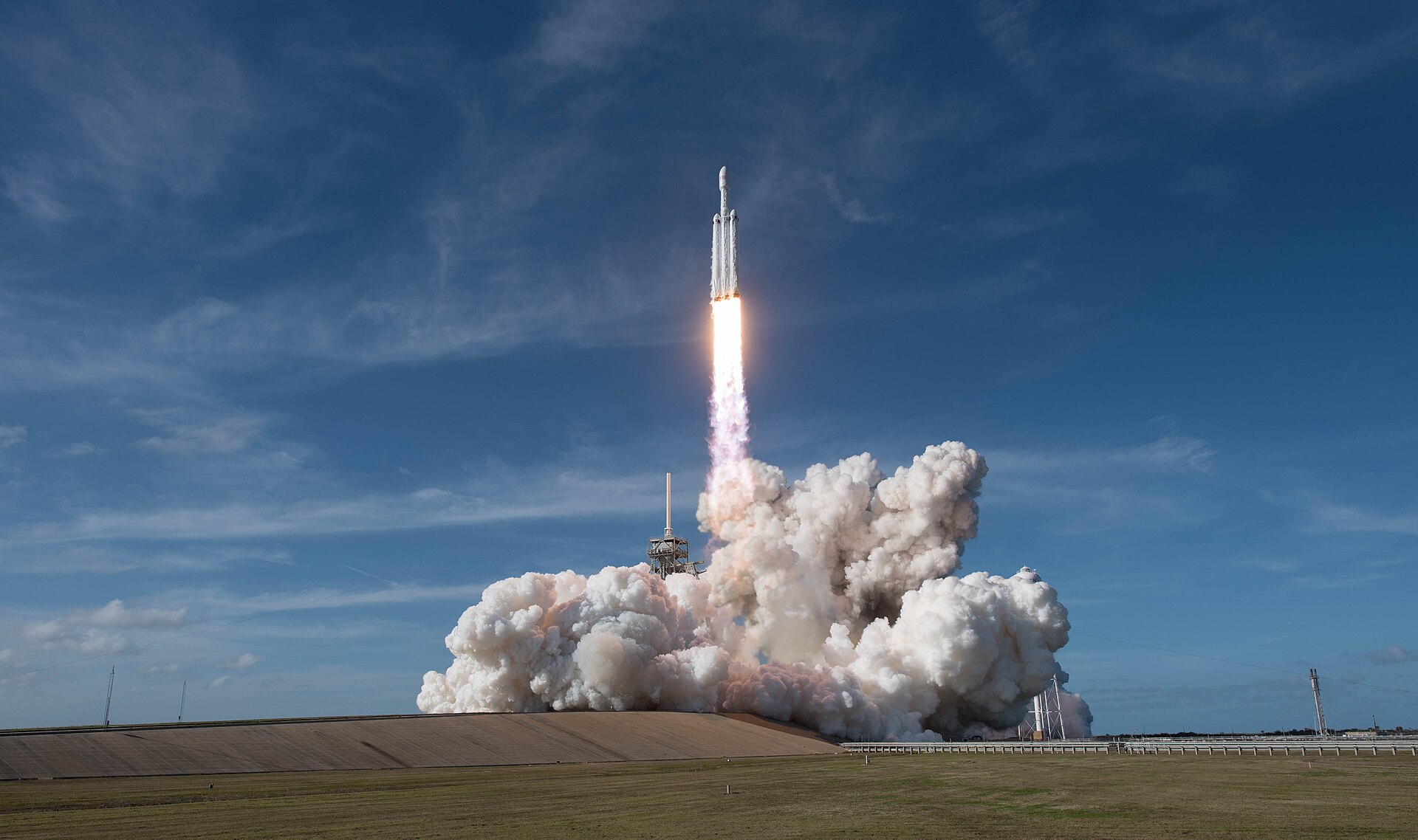Un razzo Falcon Heavy di SpaceX si prepara al lancio, con il cielo all'alba sullo sfondo.